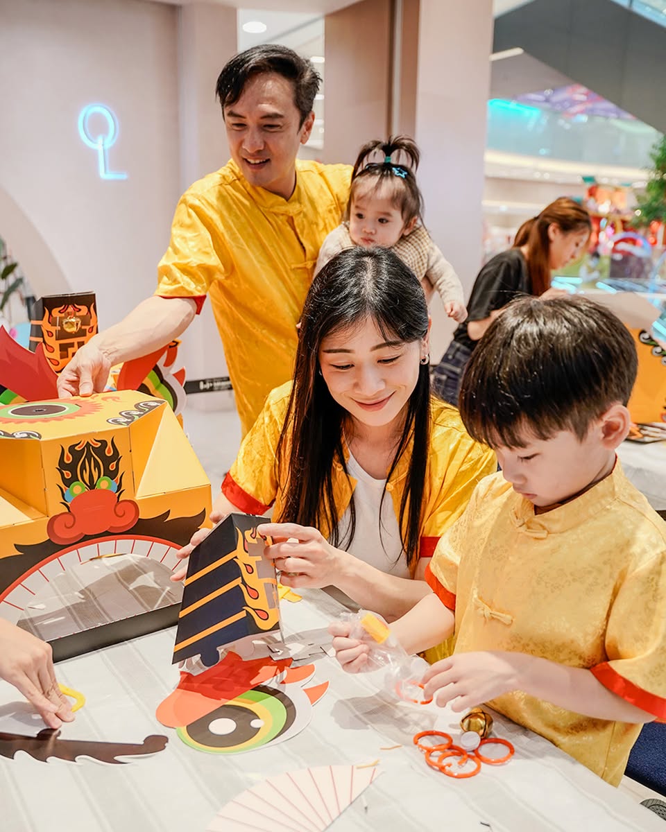 A child proudly displaying their dragon head creation