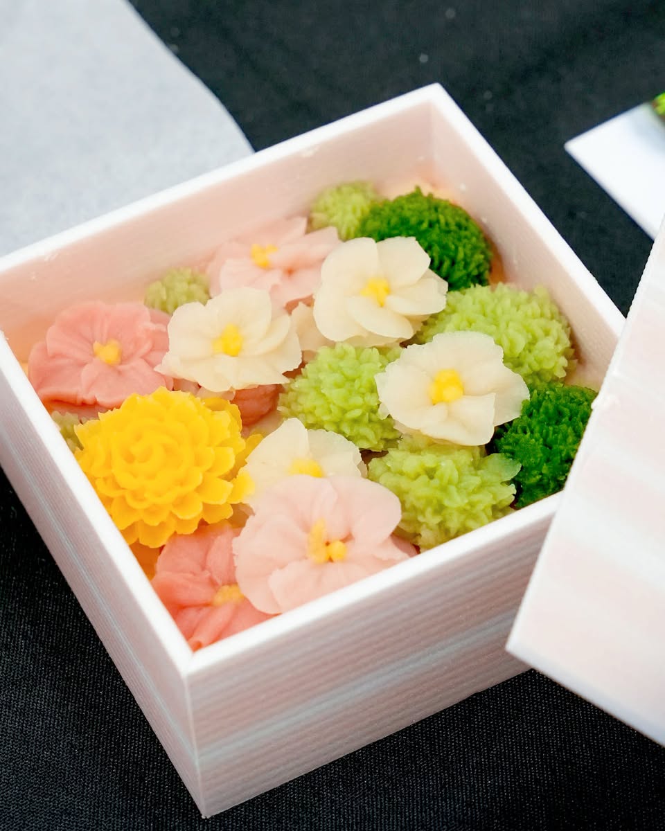 A demonstrator expertly whisking matcha in a traditional bowl