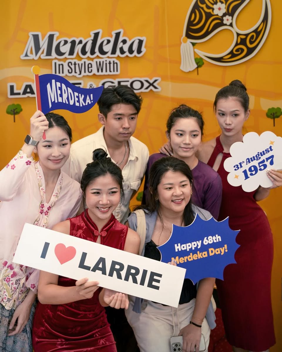 Individuals interacting with products at the LARRIE and GEOX Merdeka event.