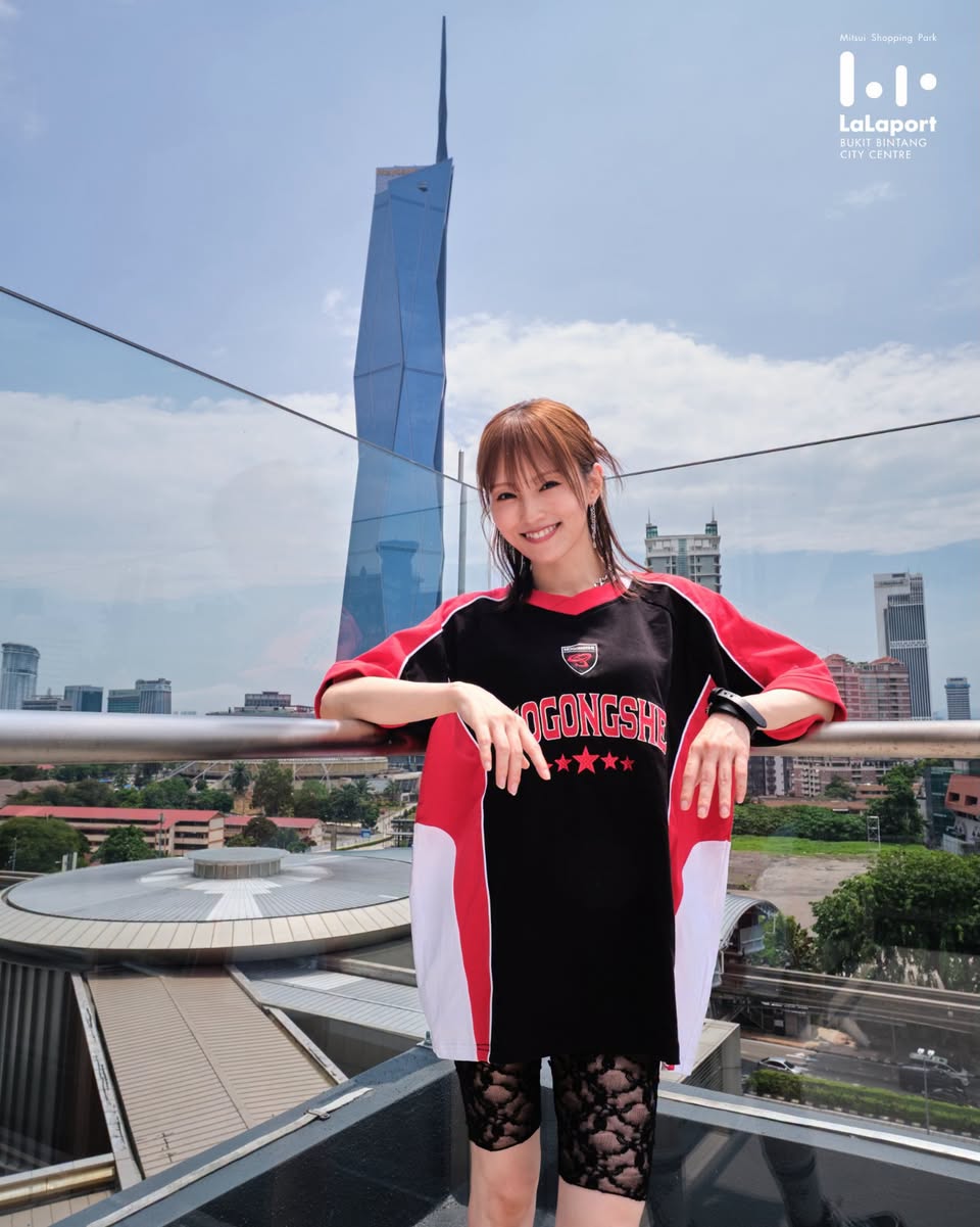 Visitor posing with KL skyline including Petronas Twin Towers from LaLaport rooftop