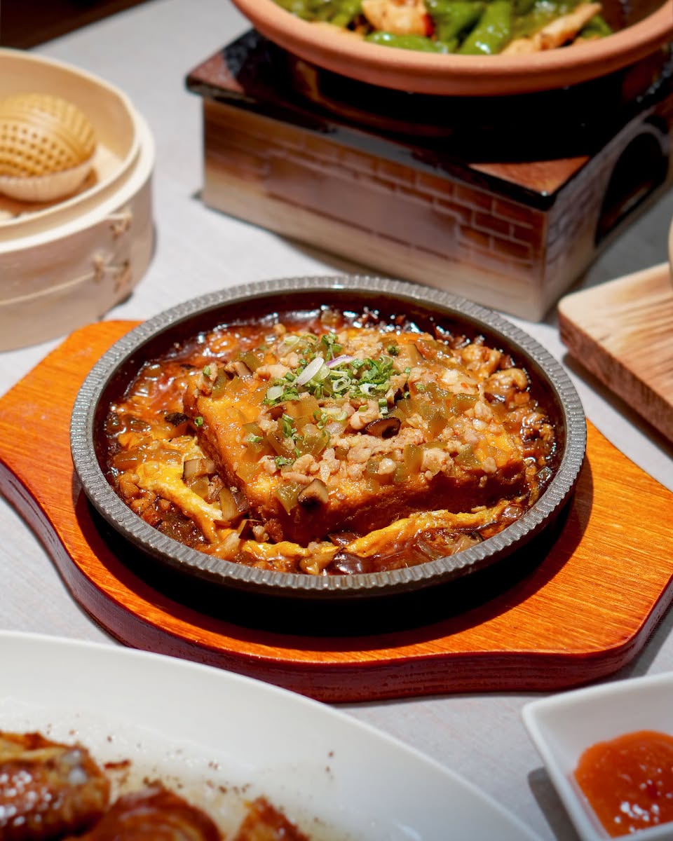 A customer enjoying a meal at LèTen Dim Sum, chopsticks in hand.