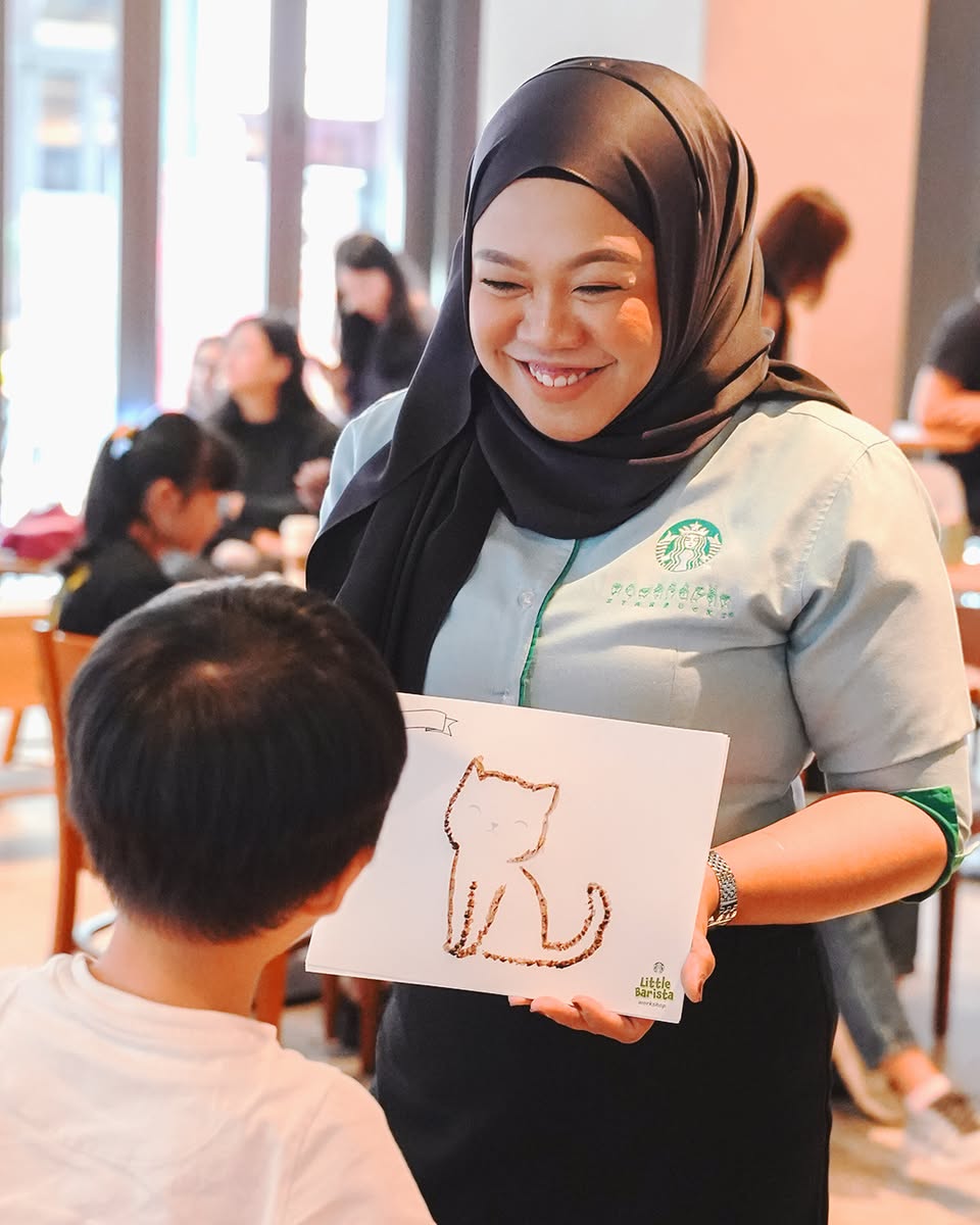 A child proudly presenting their homemade beverage at the workshop