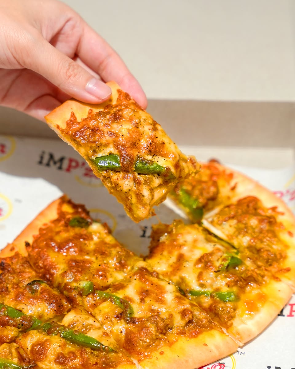 A vibrant display of freshly baked pizzas and savory rolls.