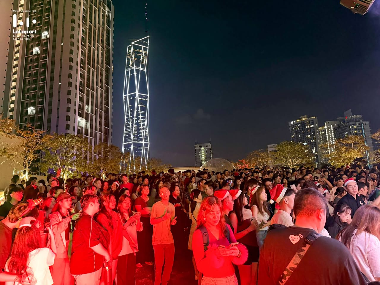 A DJ performing at Jingle Jam, with a lively dance floor in front.