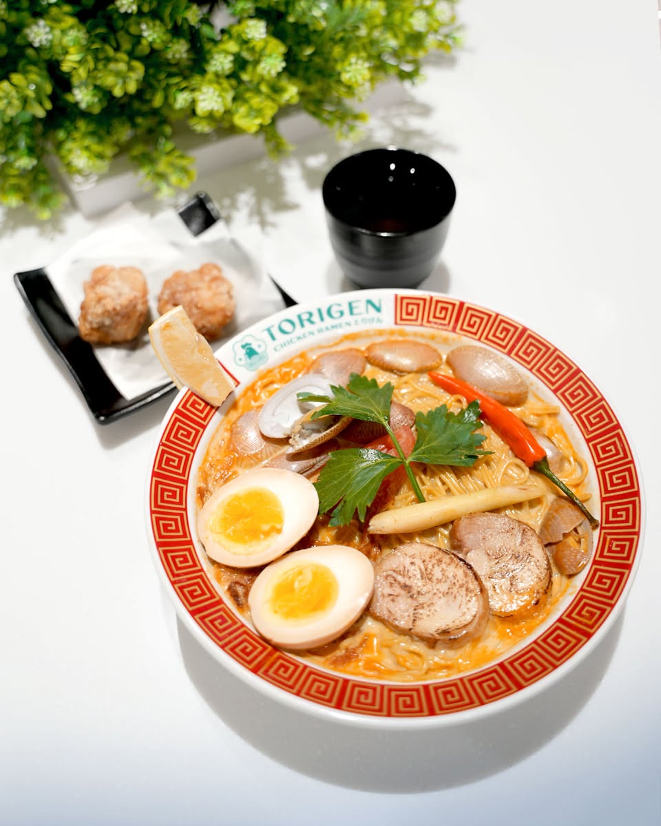 Close-up of a steaming bowl of Torigen Chicken Ramen with rich broth and toppings